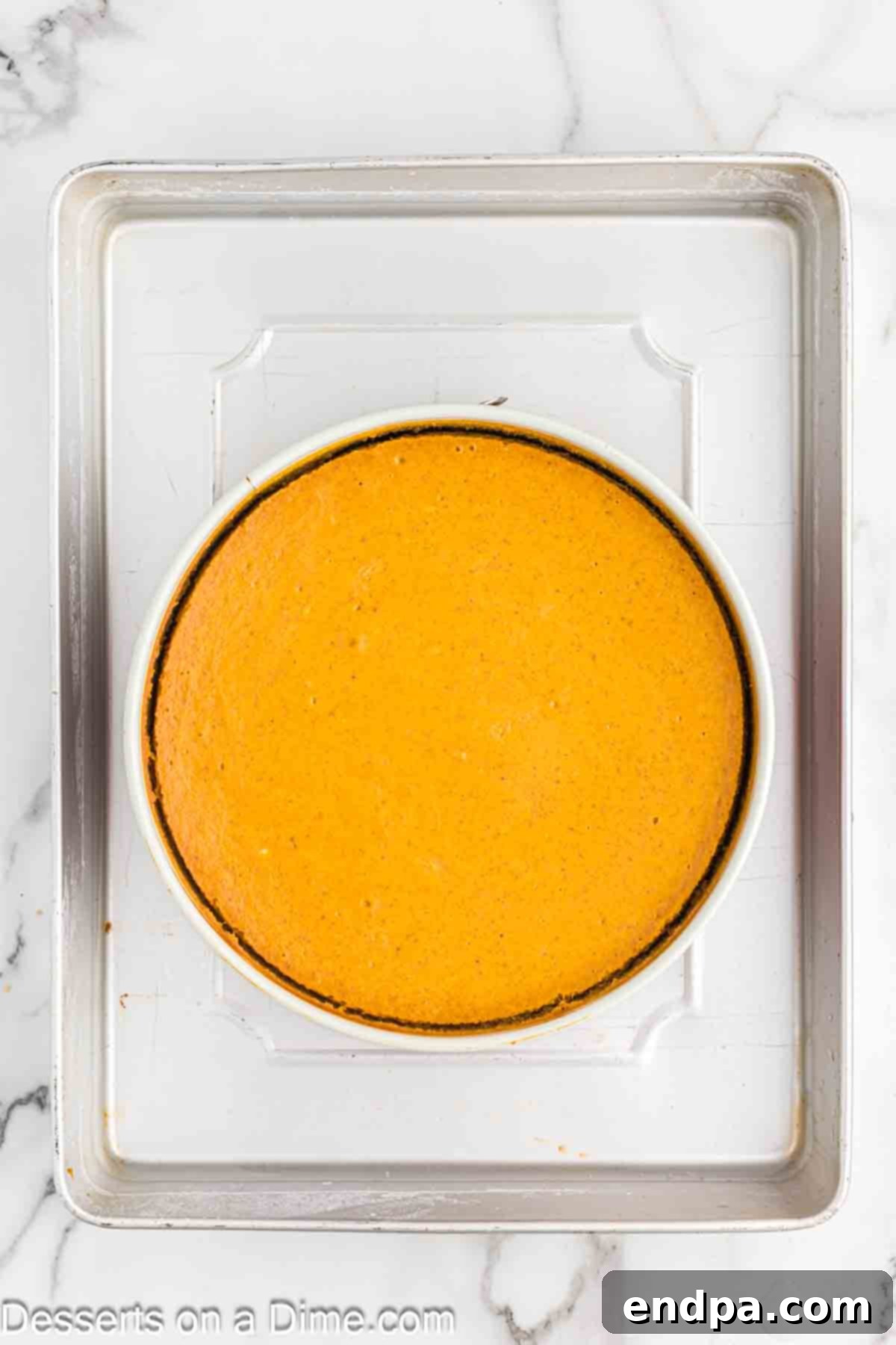 Velvet Pumpkin Spice Cheesecake 7 A springform pan containing the pumpkin cheesecake batter, wrapped in foil and placed inside a larger roasting pan filled with boiling water for a water bath, ready for oven baking.