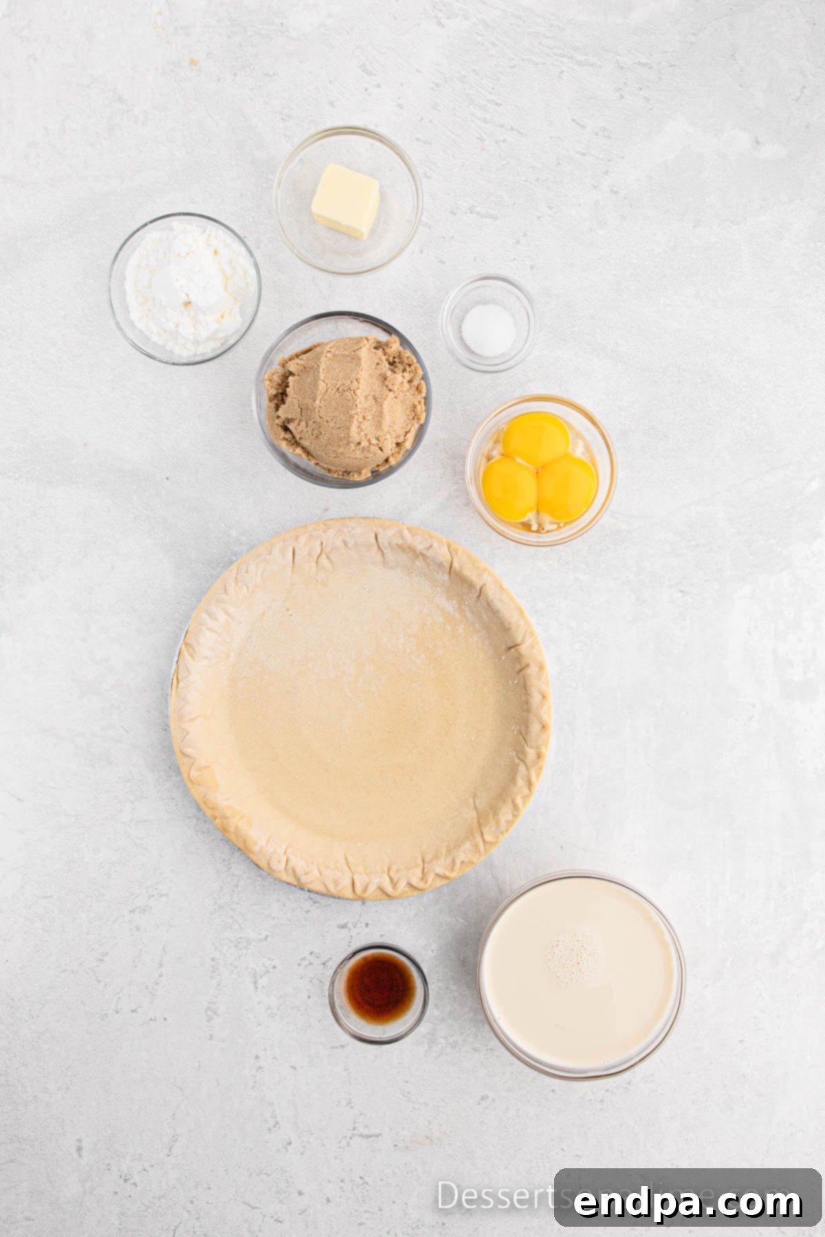 Golden Butterscotch Delight 3 A flat lay showing all the necessary ingredients for a delicious Butterscotch pie: an unbaked pie crust in a dish, a can of evaporated milk, a measuring cup of packed brown sugar, a bowl of cornstarch, separated egg yolks, a small bottle of vanilla extract, a pinch of salt, two tablespoons of butter, a bottle of butterscotch syrup, and a bowl of fluffy whipped cream.