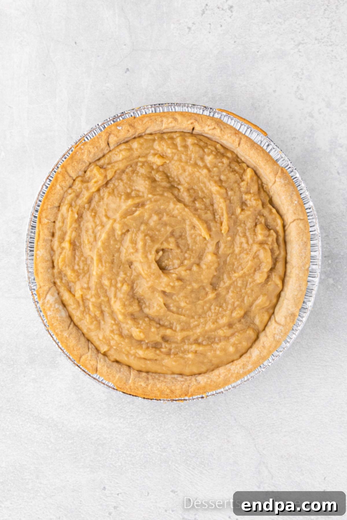 Golden Butterscotch Delight 6 The hot, thick, and perfectly smooth butterscotch pie filling is being carefully and evenly poured into the pre-baked and completely cooled pie crust, nestled in a pie plate, ready to be chilled and set.