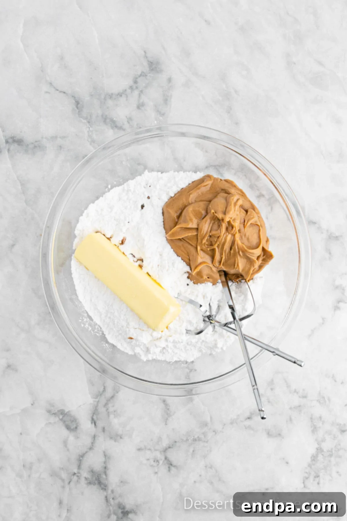 Softened butter, confectioners' sugar, creamy peanut butter, and vanilla extract are combined in a large mixing bowl.