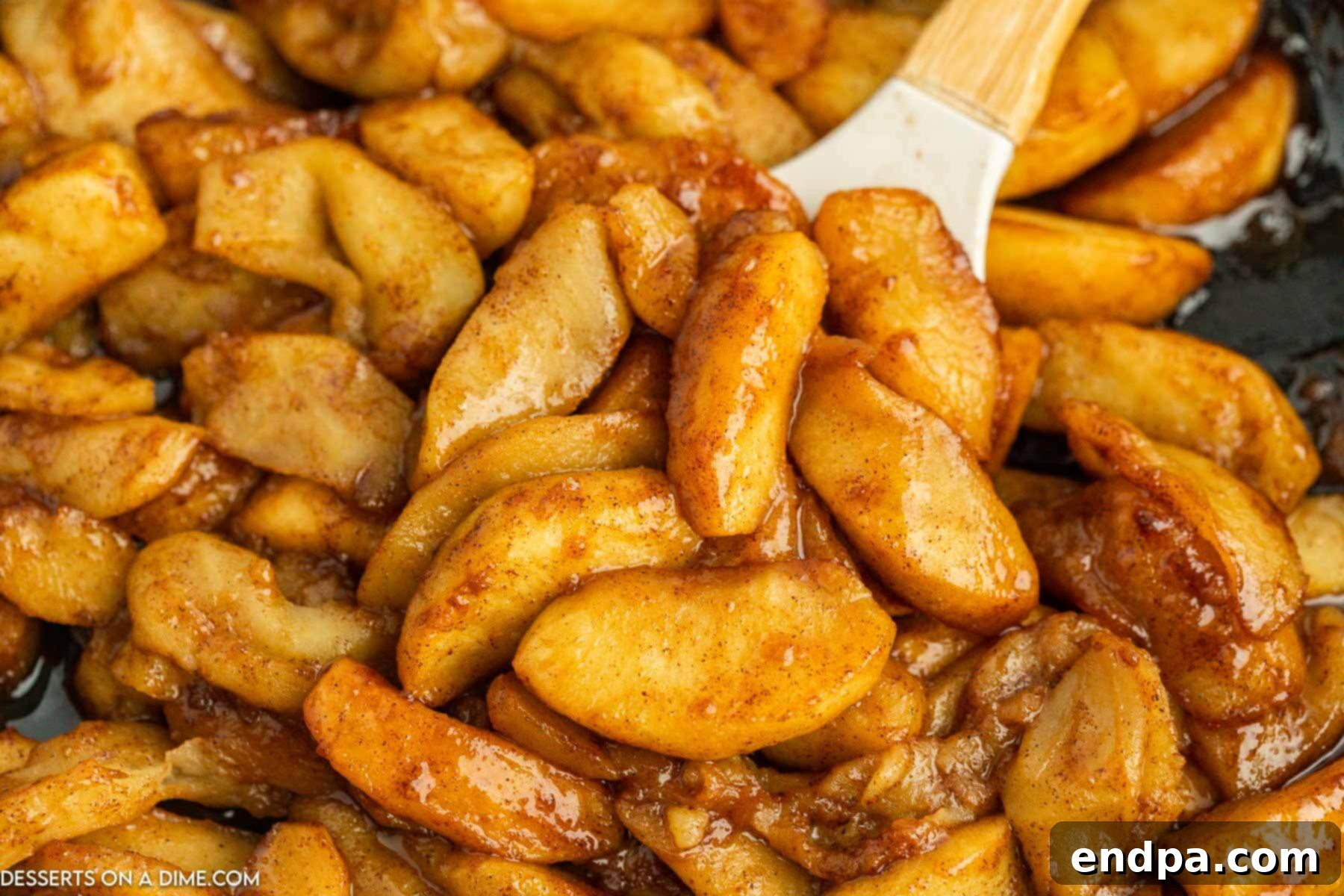 Golden brown fried apples simmering in a skillet, ready to be served.