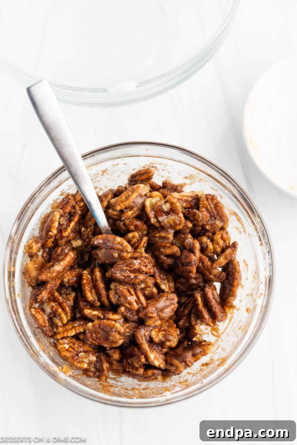 Irresistible Air Fryer Candied Pecans 6 Pecans coated in cinnamon and sugar mixture in a bowl.