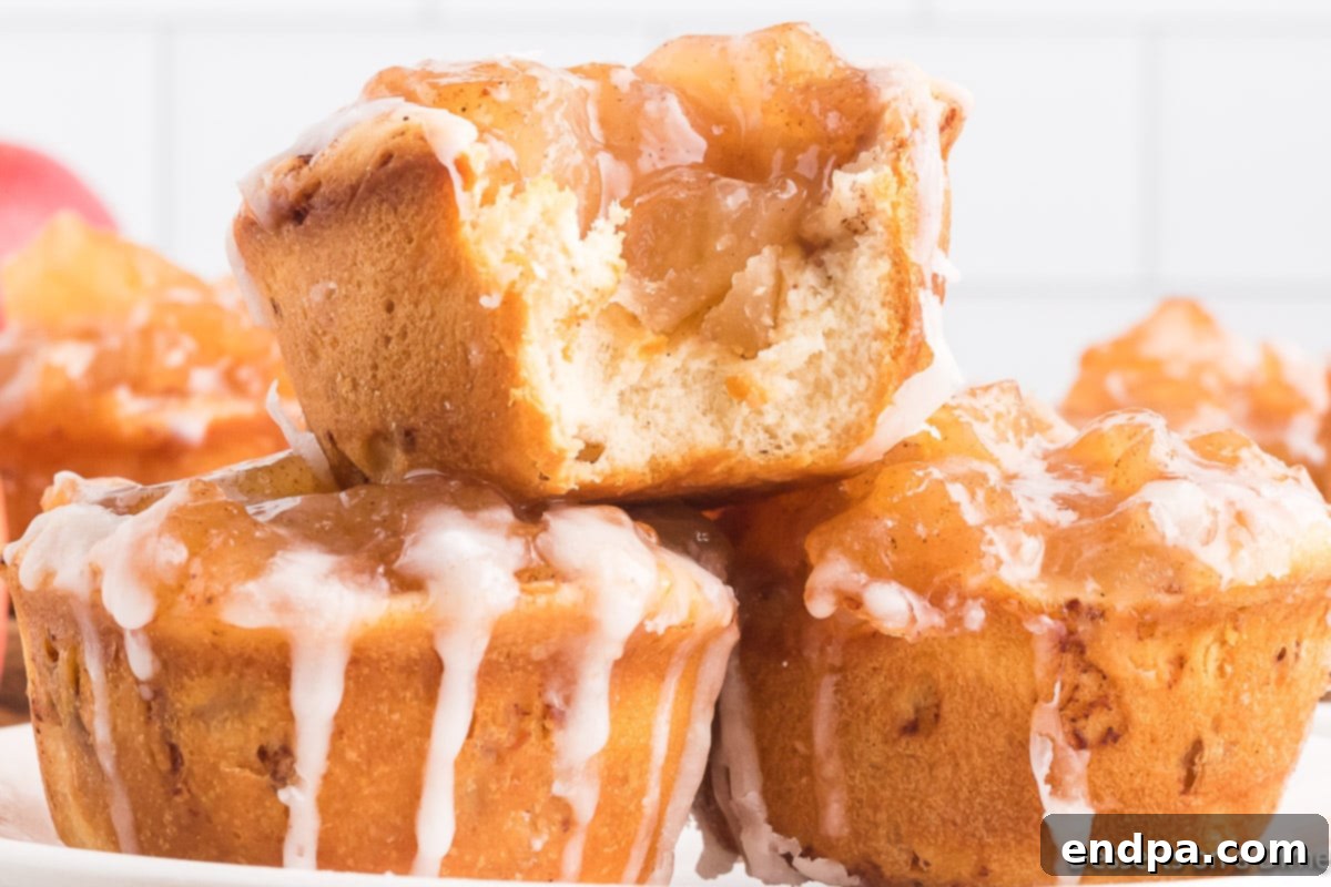 Cinnamon Roll Apple Pie Cups stacked on a rustic wooden board, ready to be enjoyed. 