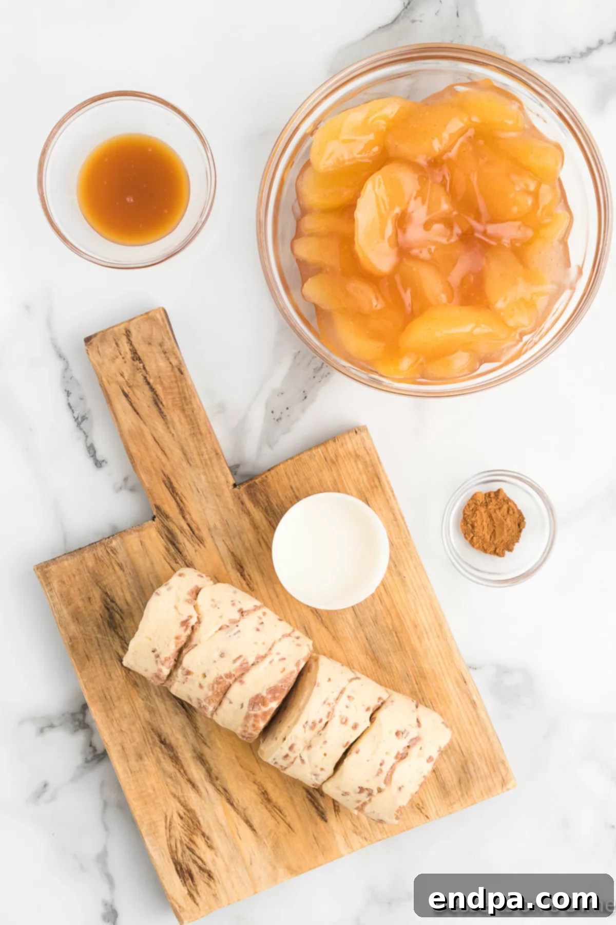 Key ingredients for Cinnamon Roll Apple Pie Cups: cinnamon rolls, apple pie filling, caramel sauce, and ground cinnamon.