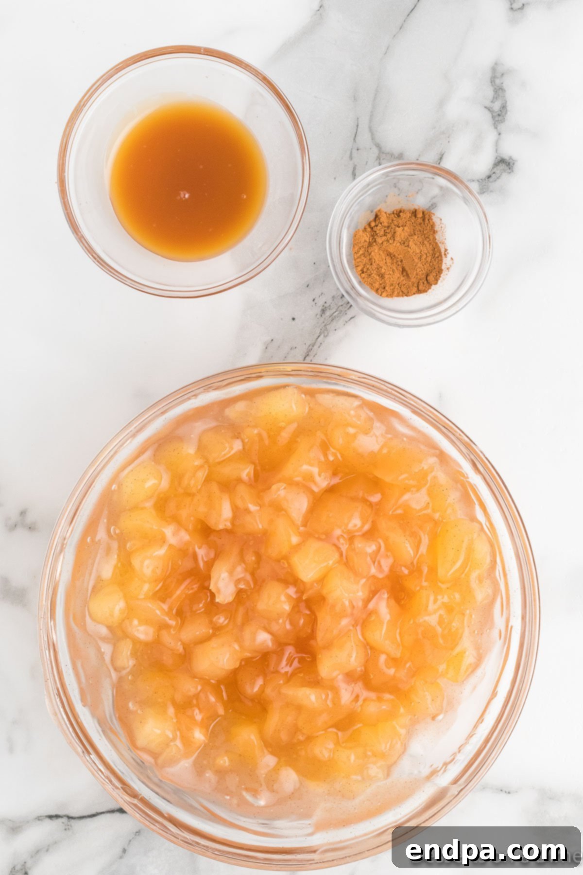 Apple pie filling in a mixing bowl, ready to be enhanced with spices and caramel.