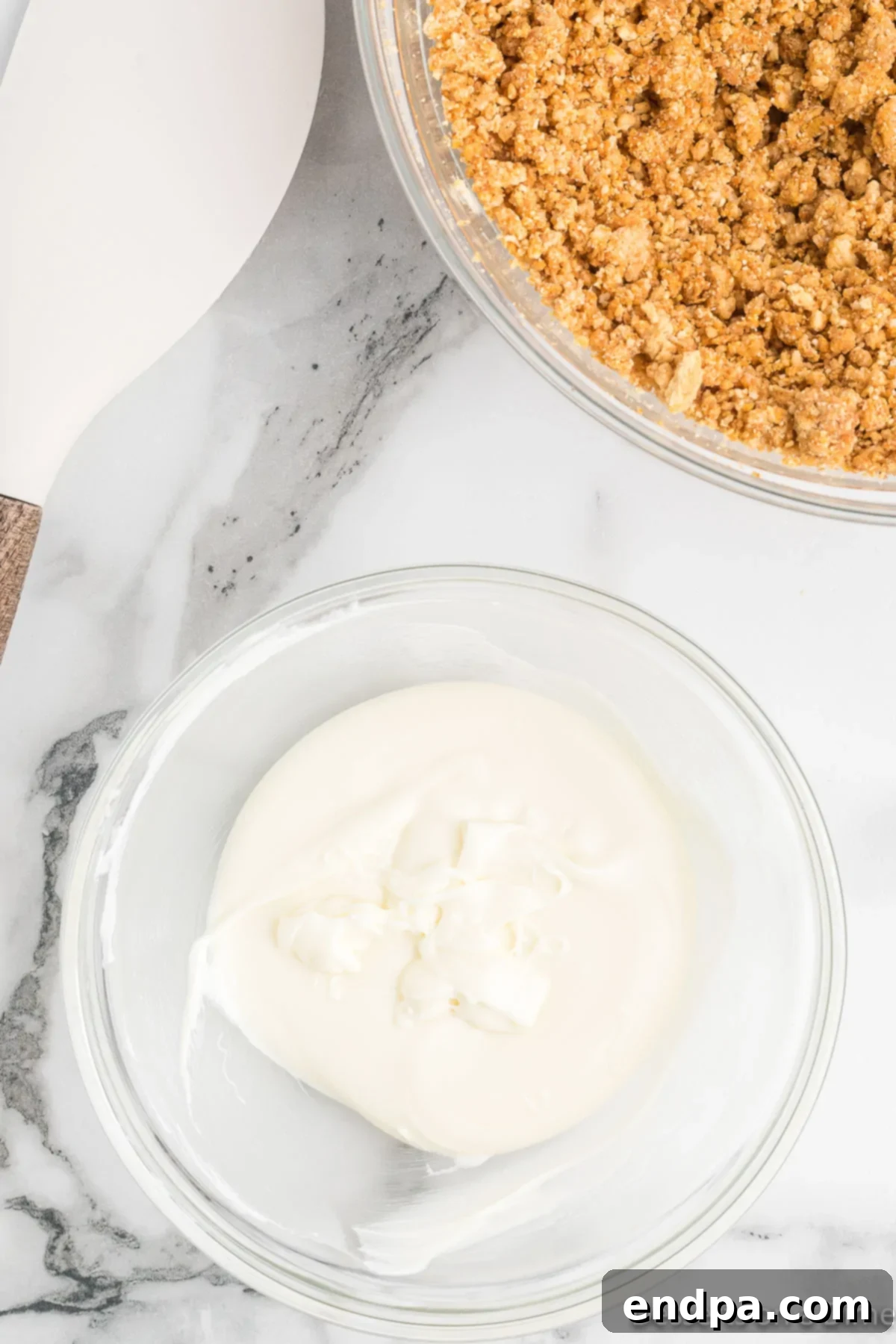 Melted white chocolate chips in a microwave-safe bowl.
