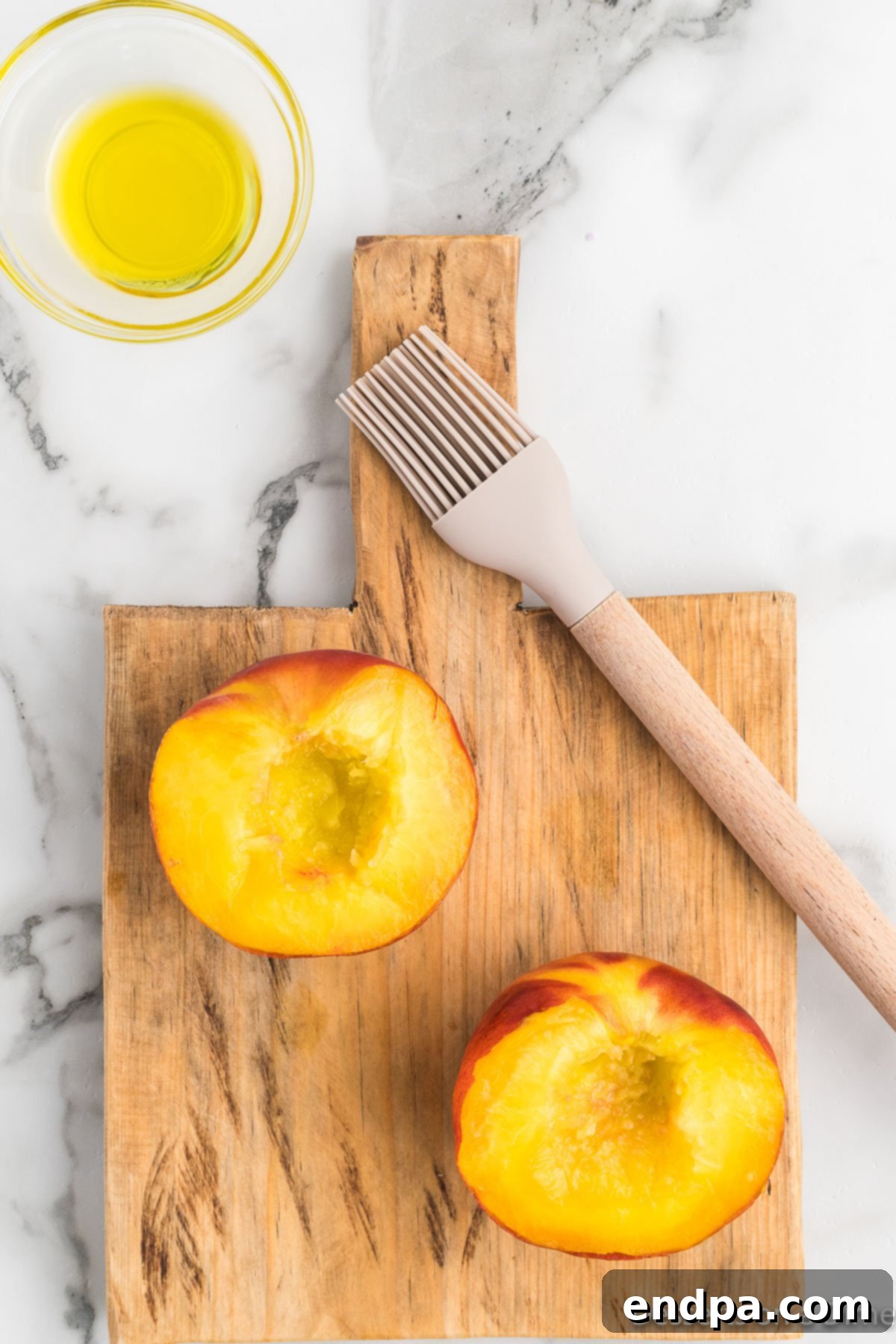 Golden Air Fryer Peaches 6 Peaches cut in half on cutting board with olive oil.