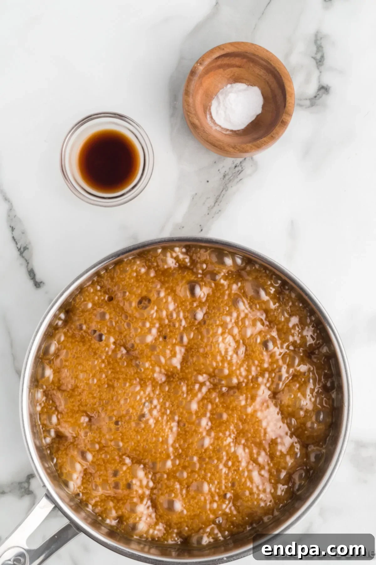 The butter, brown sugar, corn syrup, and salt mixture coming to a boil in a saucepan, being stirred constantly.