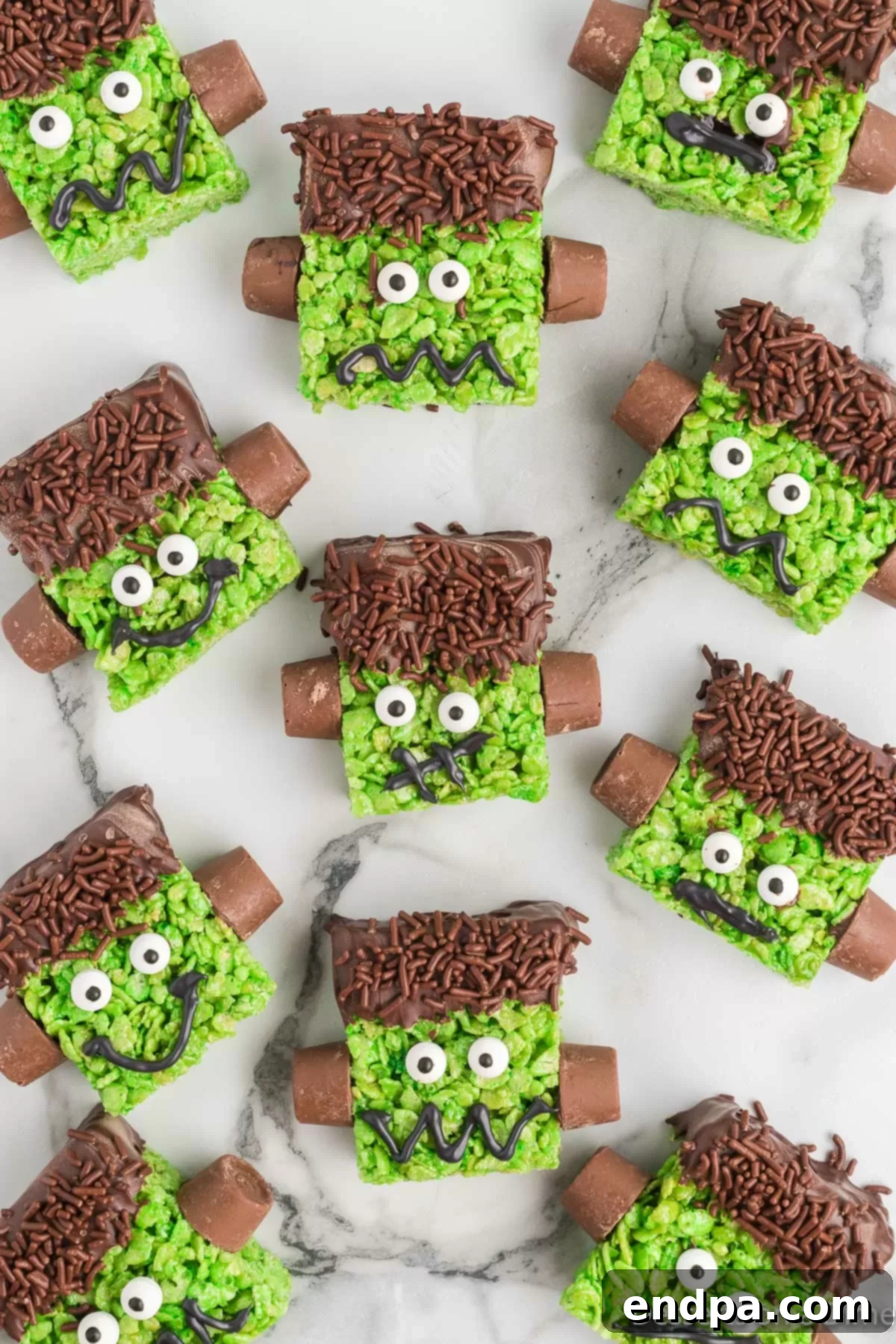 Frankenstein rice krispie treats decorated and ready to enjoy on a Halloween-themed plate.