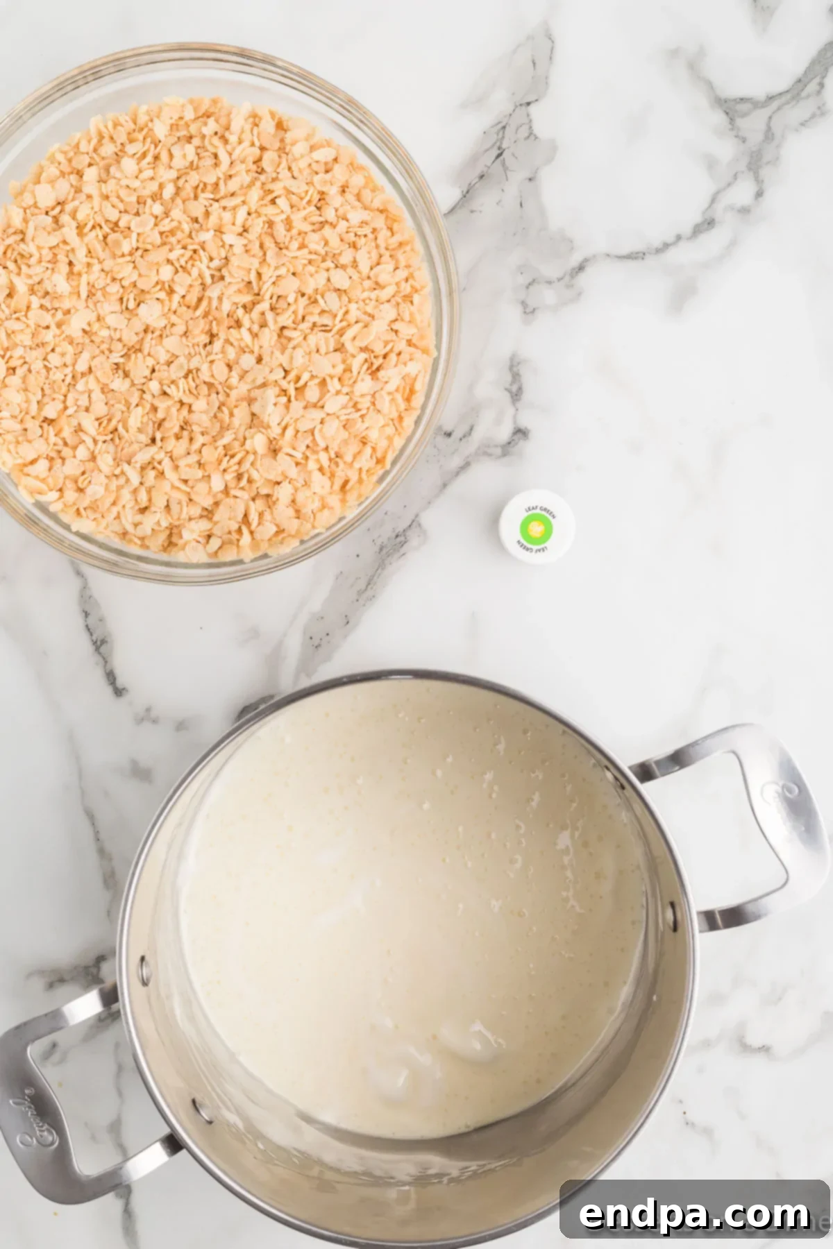 Melted marshmallows and butter in a large saucepan, ready for food coloring.