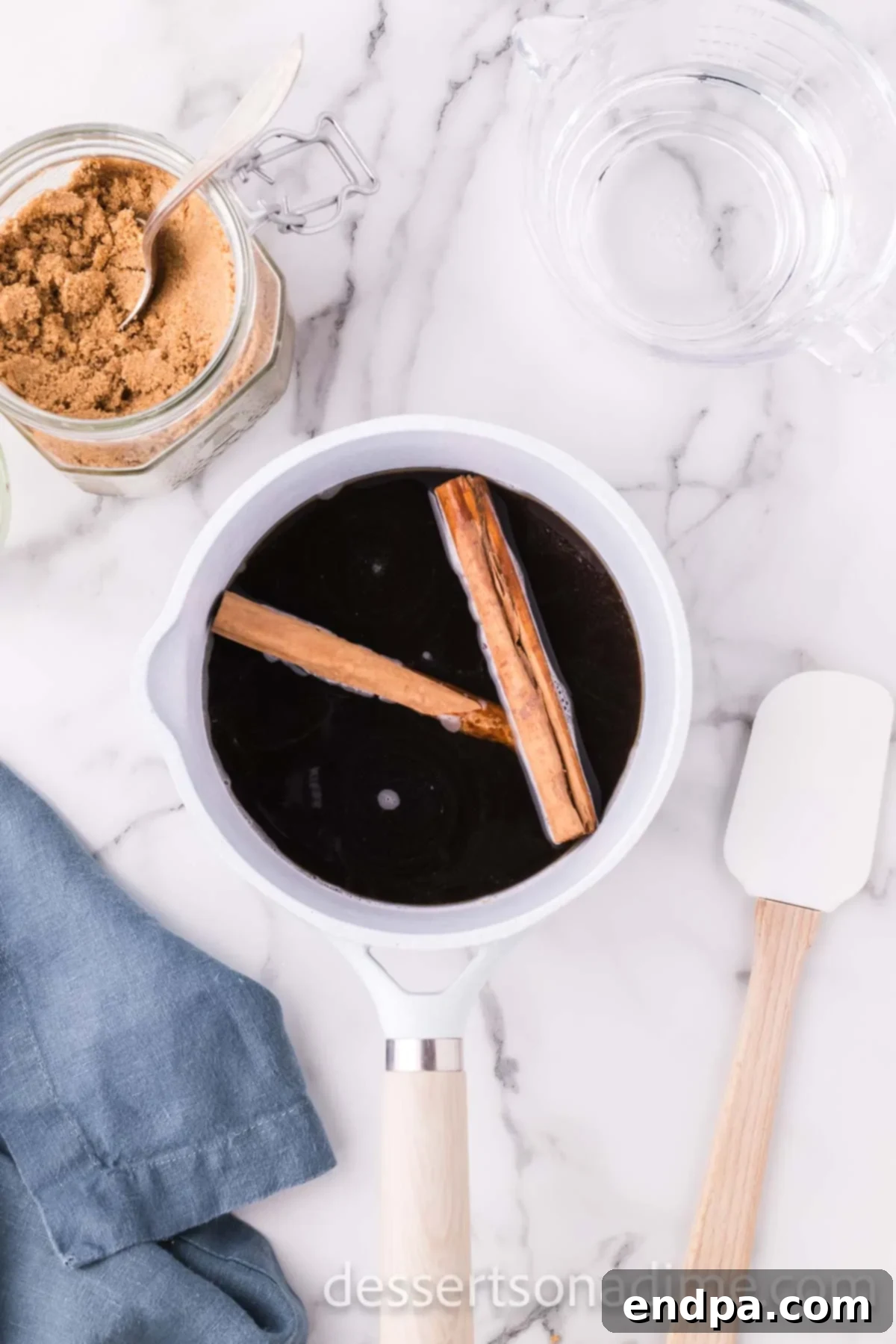 Fragrant cinnamon sticks carefully added to the brown sugar and water mixture in the saucepan.