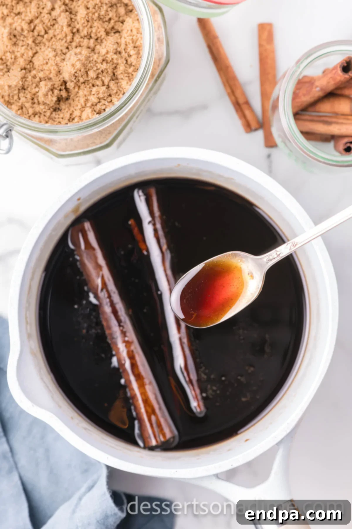 Cinnamon sticks simmering gently in the rich brown sugar syrup, infusing their warm aroma.