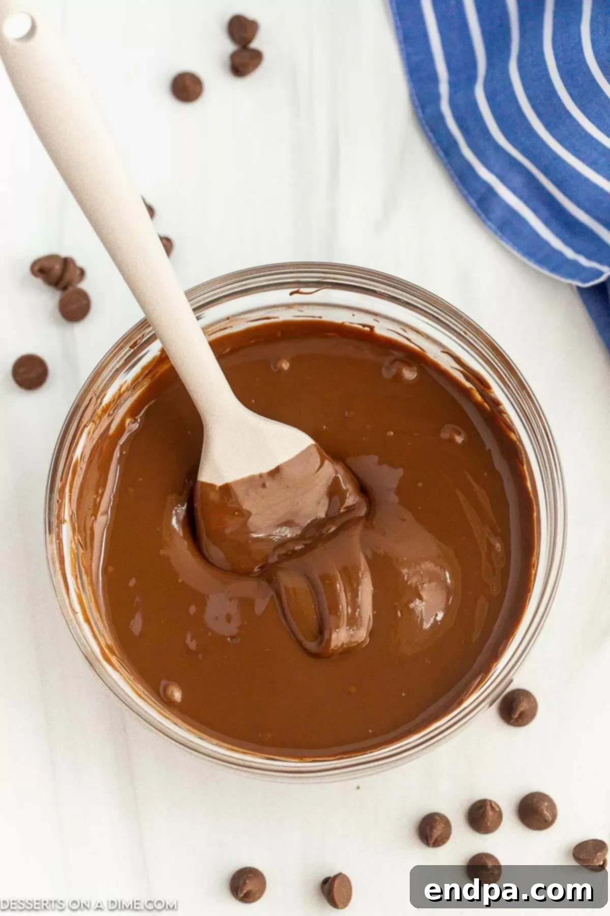 Melted Chocolate in a clear bowl with a spoon