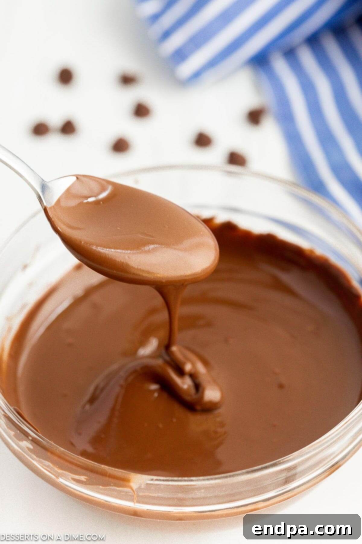 Melted Chocolate in a clear bowl with a spoon