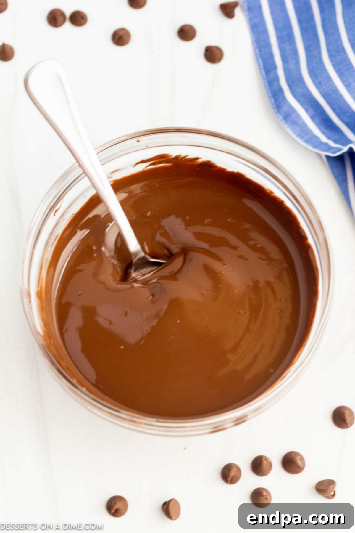 Melted Chocolate in a clear bowl with a spoon