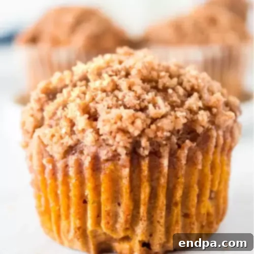 97 Effortless Autumn Delights 11 Pumpkin Muffins topped with a generous layer of cinnamon streusel.