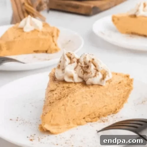97 Effortless Autumn Delights 17 A slice of creamy No-Bake Pumpkin Pie on a white plate, ready to enjoy.