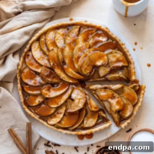 97 Effortless Autumn Delights 34 An elegant Caramel Apple Tart with thinly sliced apples and a golden crust.
