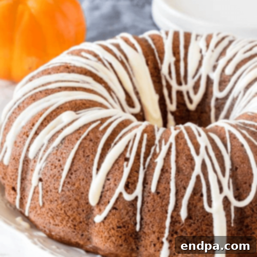 97 Effortless Autumn Delights 43 A festive Pumpkin Bundt Cake drizzled with cream cheese glaze.