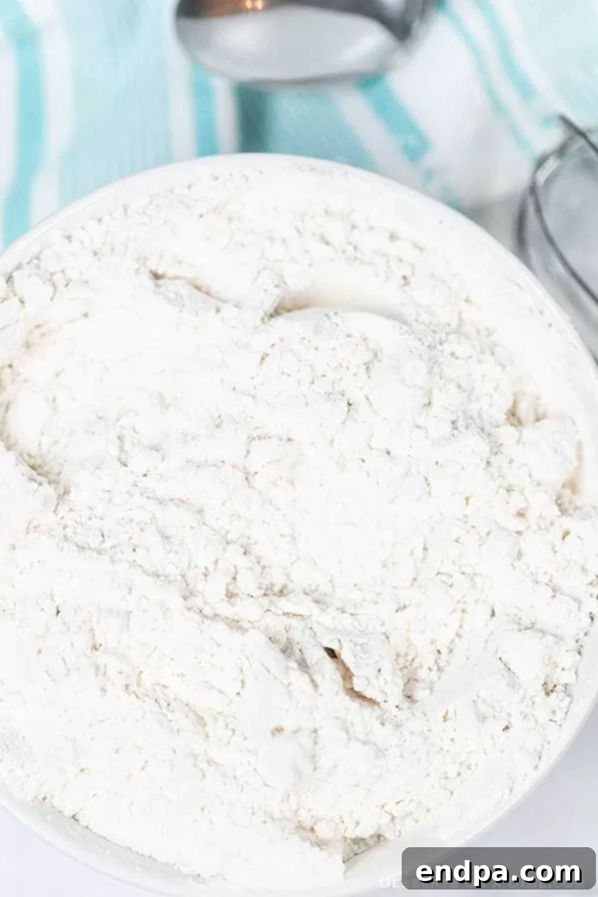 Learn how to make cake flour with only 2 ingredients. No need to buy this at the store when it is so easy to make homemade cake flour substitute for baking. This DIY cake flour recipe is perfect for recipe desserts. Homemade cake flour in a rustic bowl, ready for baking.