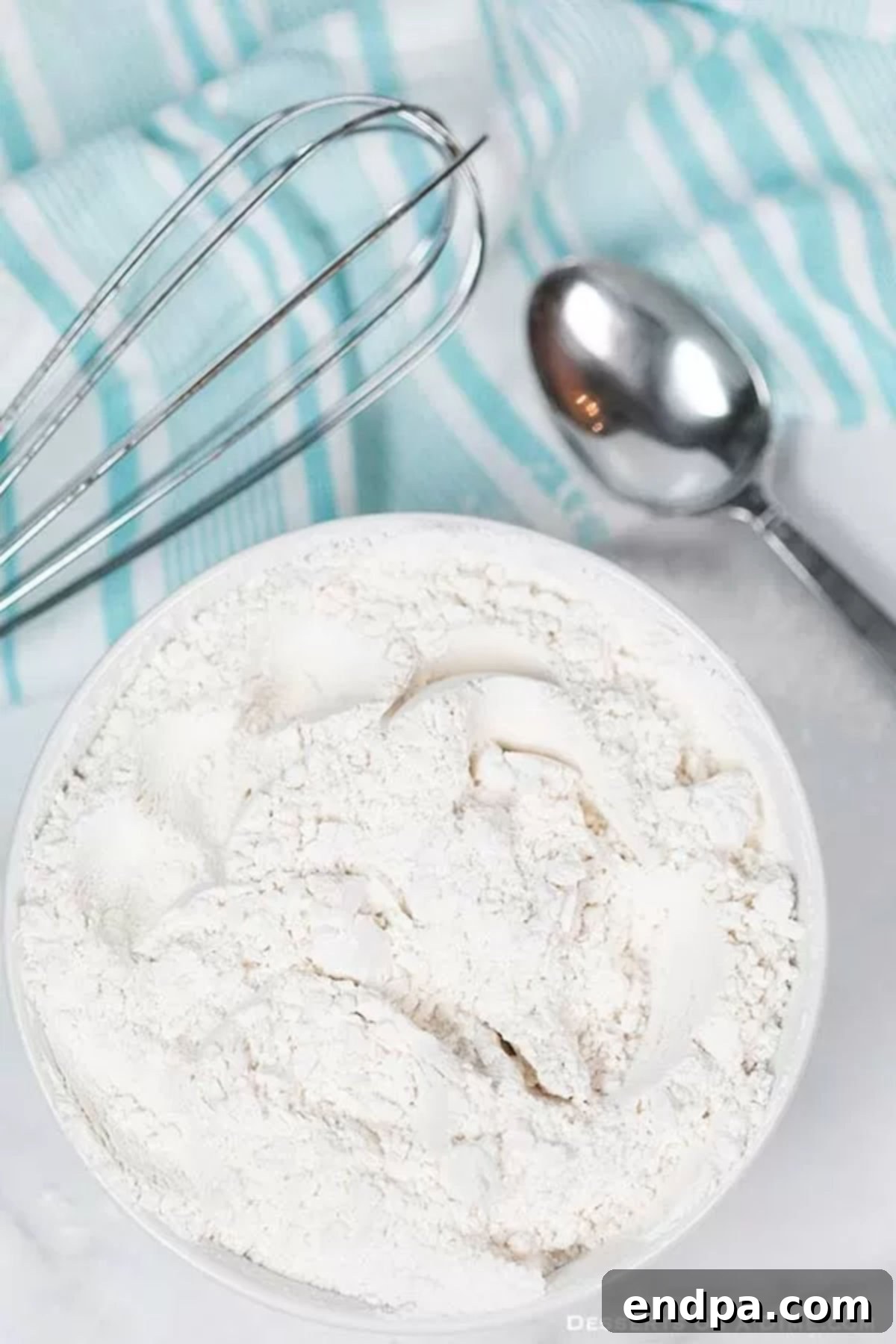 Bake Better with Homemade Cake Flour 2 A measuring cup filled with all-purpose flour, ready for preparation.