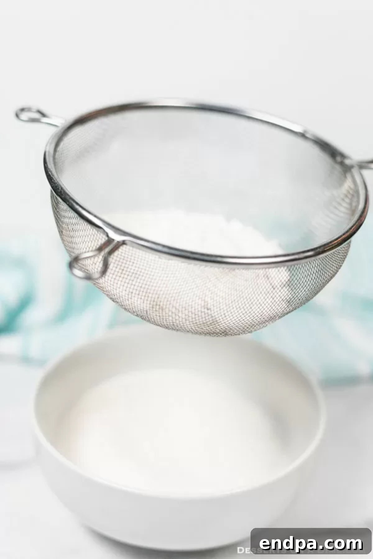 Bake Better with Homemade Cake Flour 4 The flour and cornstarch mixture being sifted through a fine-mesh sieve.