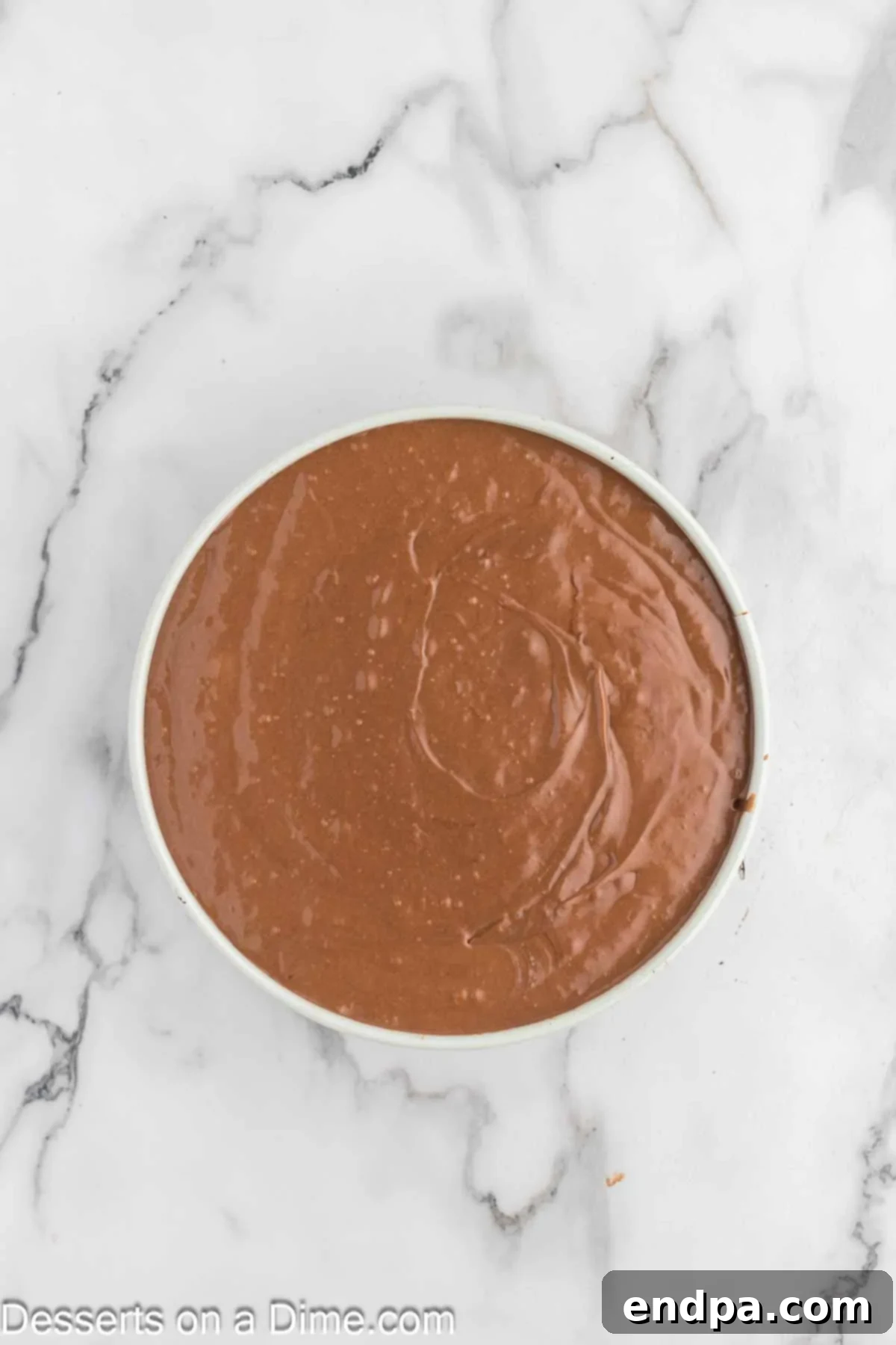 Pouring the smooth Nutella cheesecake batter into the pre-baked Oreo crust