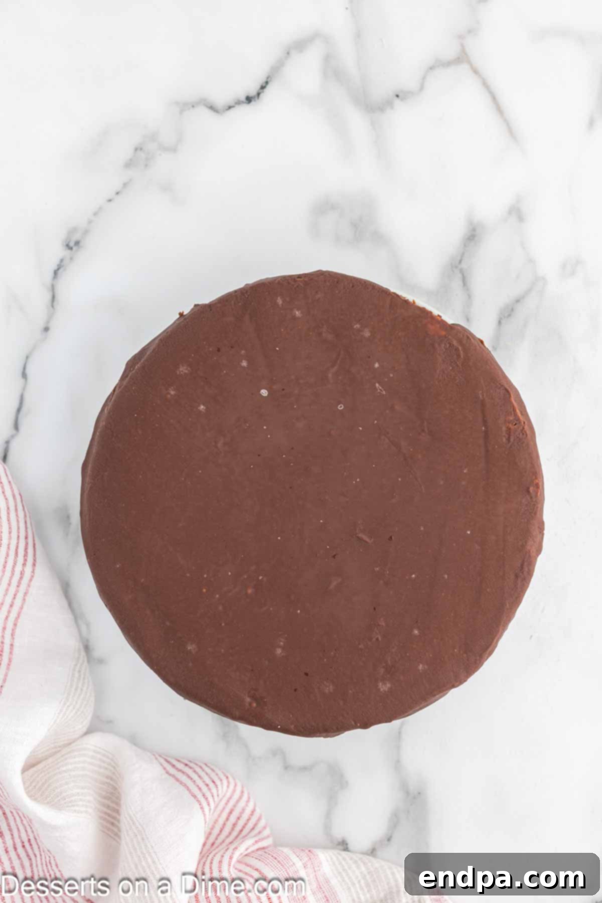 Pouring the warm Nutella glaze evenly over the top of the chilled cheesecake