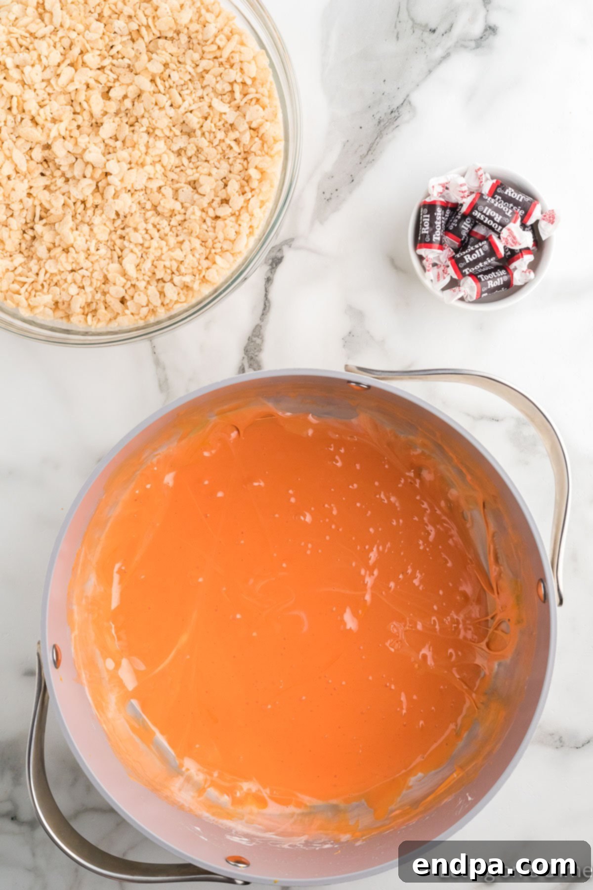 Pumpkin Patch Krispie Treats 9 Marshmallow mixture stirred until it achieves a uniform bright orange color.