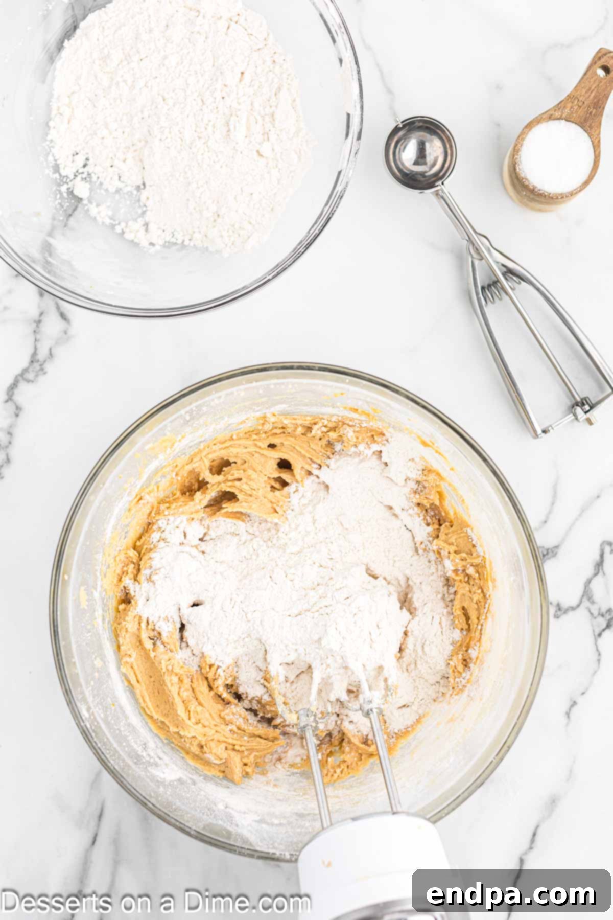 Wet and dry ingredients combined together in a bowl to form cookie dough.