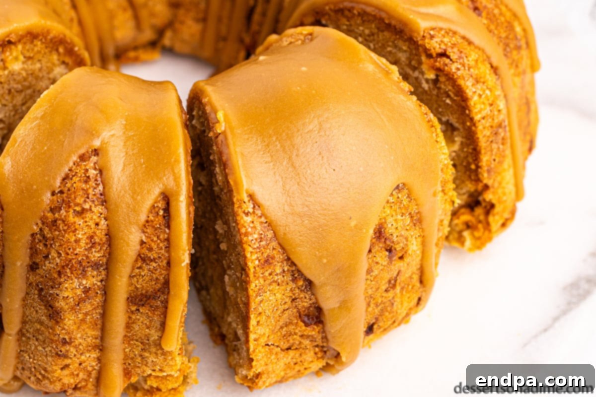 Apple bundt cake sliced on a platter, showcasing its moist interior and generous glaze.