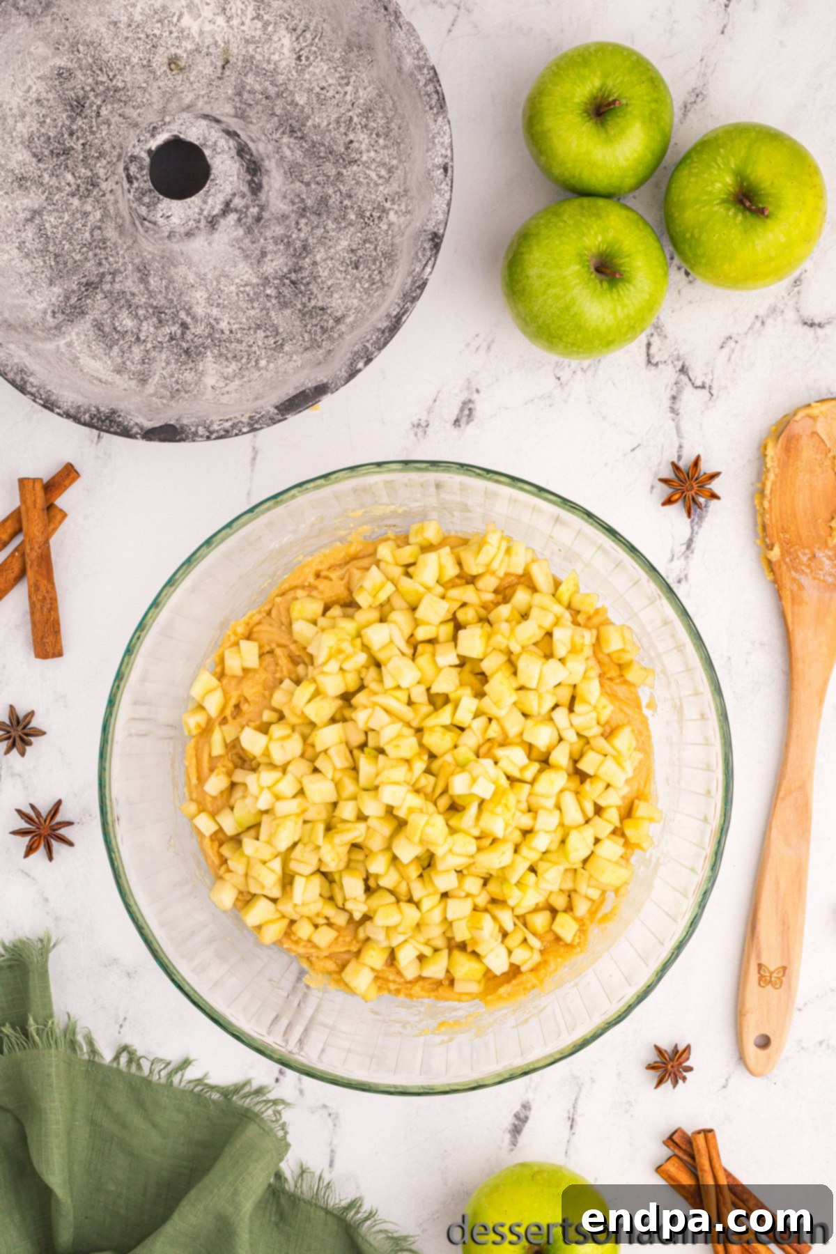 Diced apples folded into the cake batter, ready for baking.