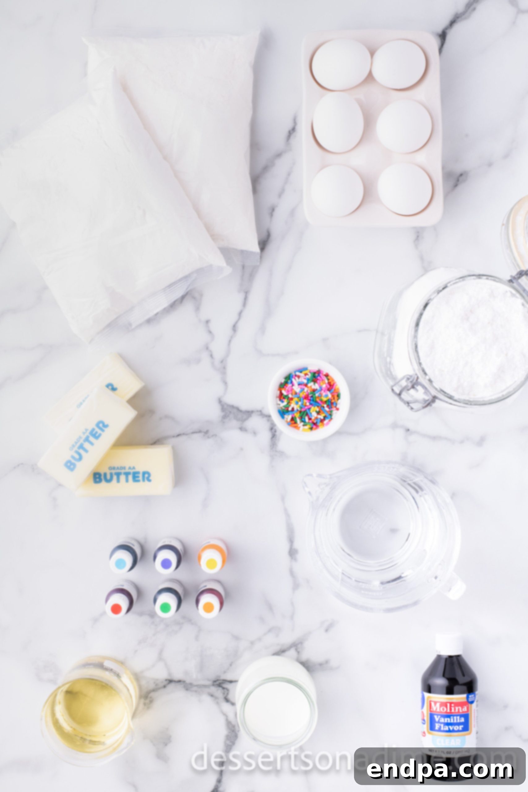 Kaleidoscope Delight 3 Ingredients for Easy Rainbow Cake: two boxes of white cake mix, fresh large eggs, gel food coloring in an array of rainbow shades, softened butter, clear vanilla extract, sifted confectioners sugar, whole milk, and optional festive rainbow sprinkles, all laid out on a clean counter.