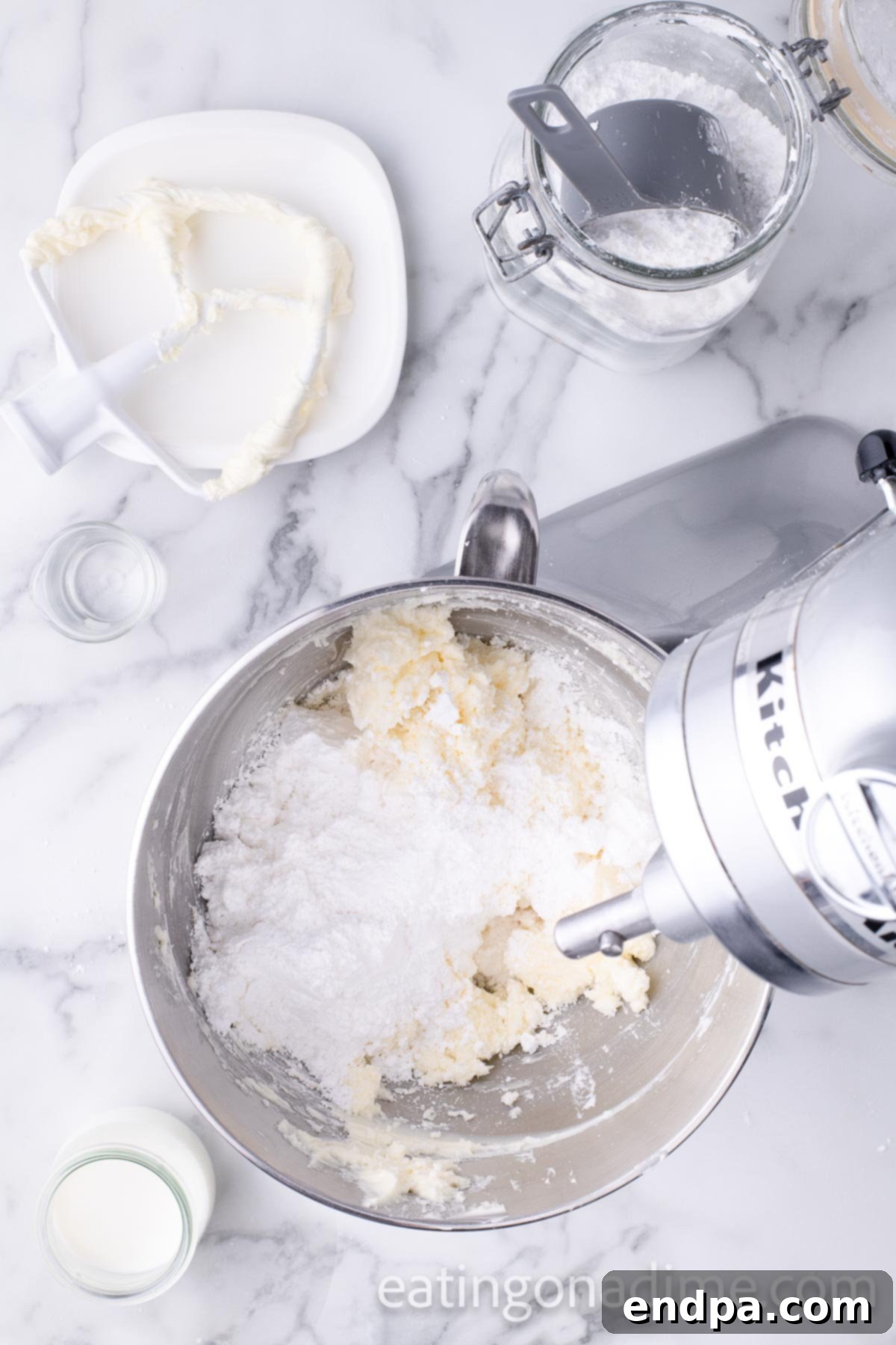 Kaleidoscope Delight 8 A stand mixer in action, creaming softened butter and gradually incorporating powdered sugar to create a smooth and fluffy homemade buttercream frosting.