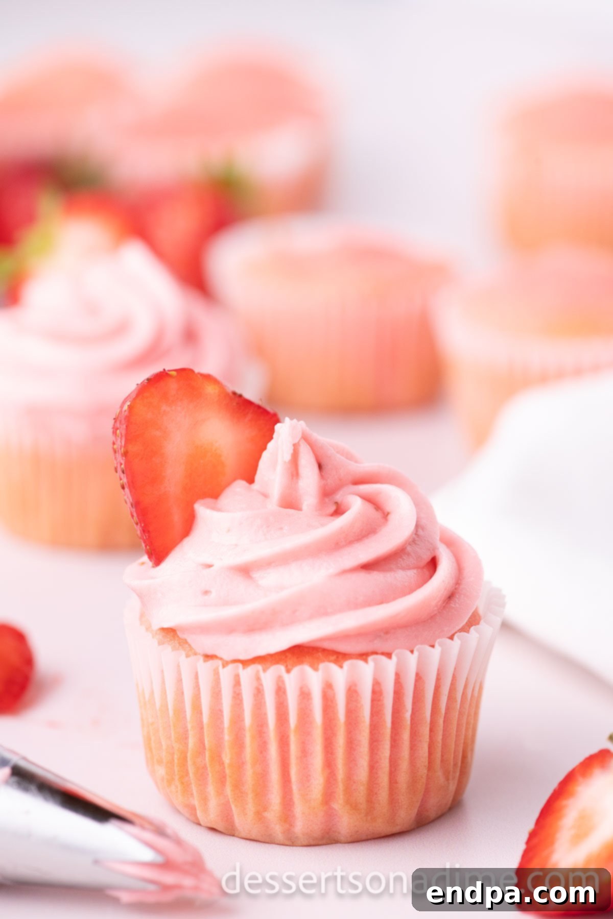 Velvety Strawberry Cream Cheese Frosting 2 A cupcake beautifully frosted with homemade Strawberry Cream Cheese Frosting, garnished with a fresh strawberry slice.