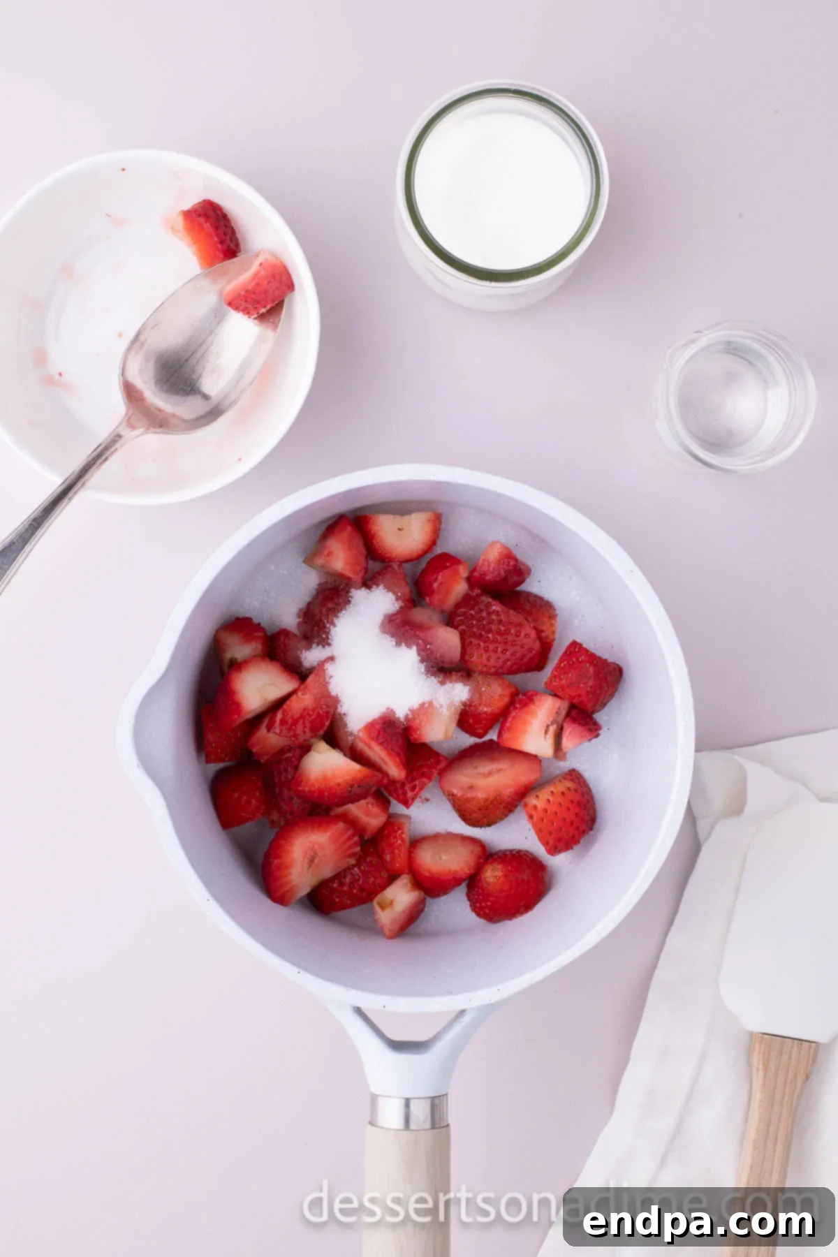 Velvety Strawberry Cream Cheese Frosting 4 Freshly chopped strawberries and granulated sugar cooking together in a saucepan to create a delicious puree.