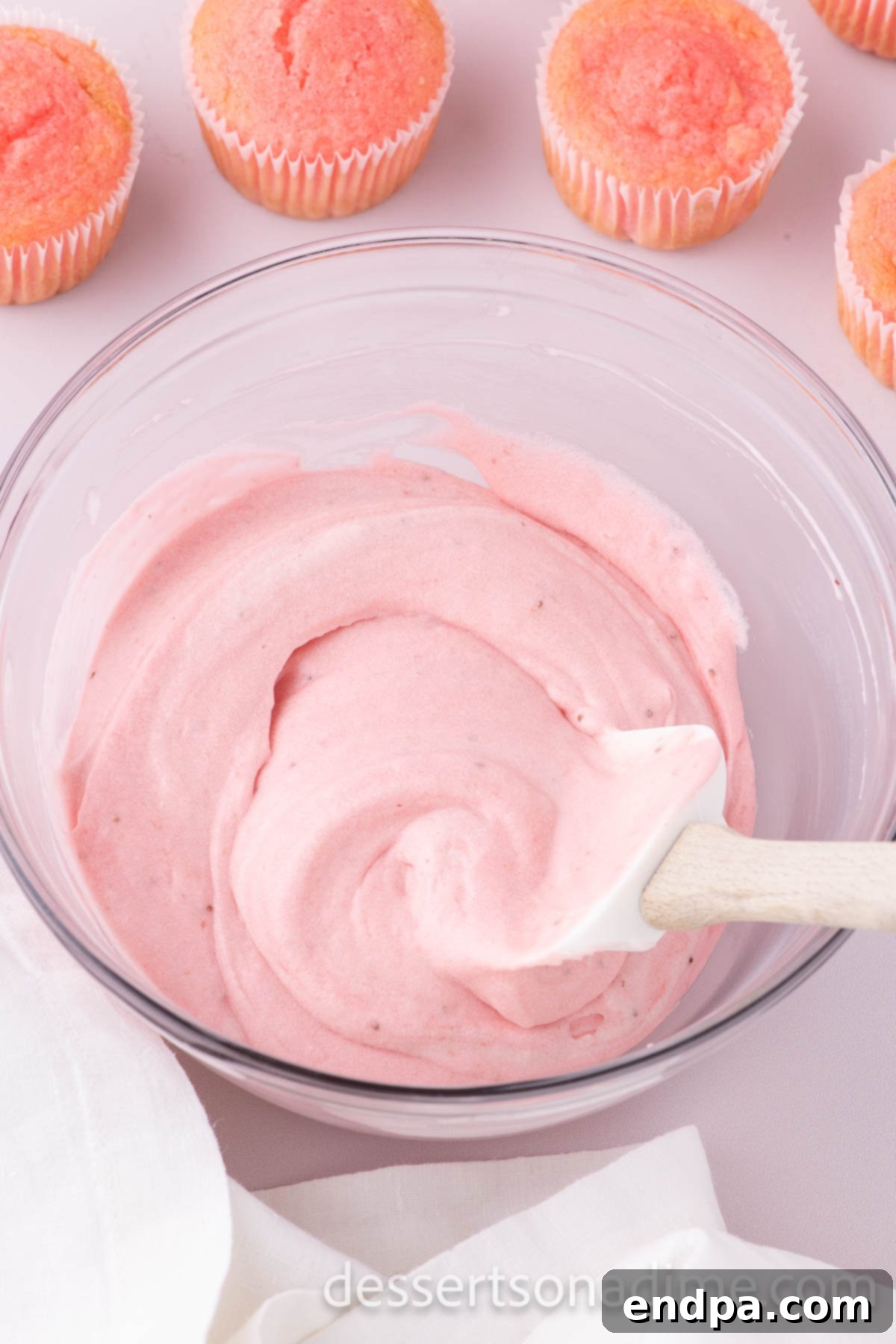 Velvety Strawberry Cream Cheese Frosting 8 Sifted powdered sugar being gradually mixed into the strawberry cream cheese base until creamy and thick.
