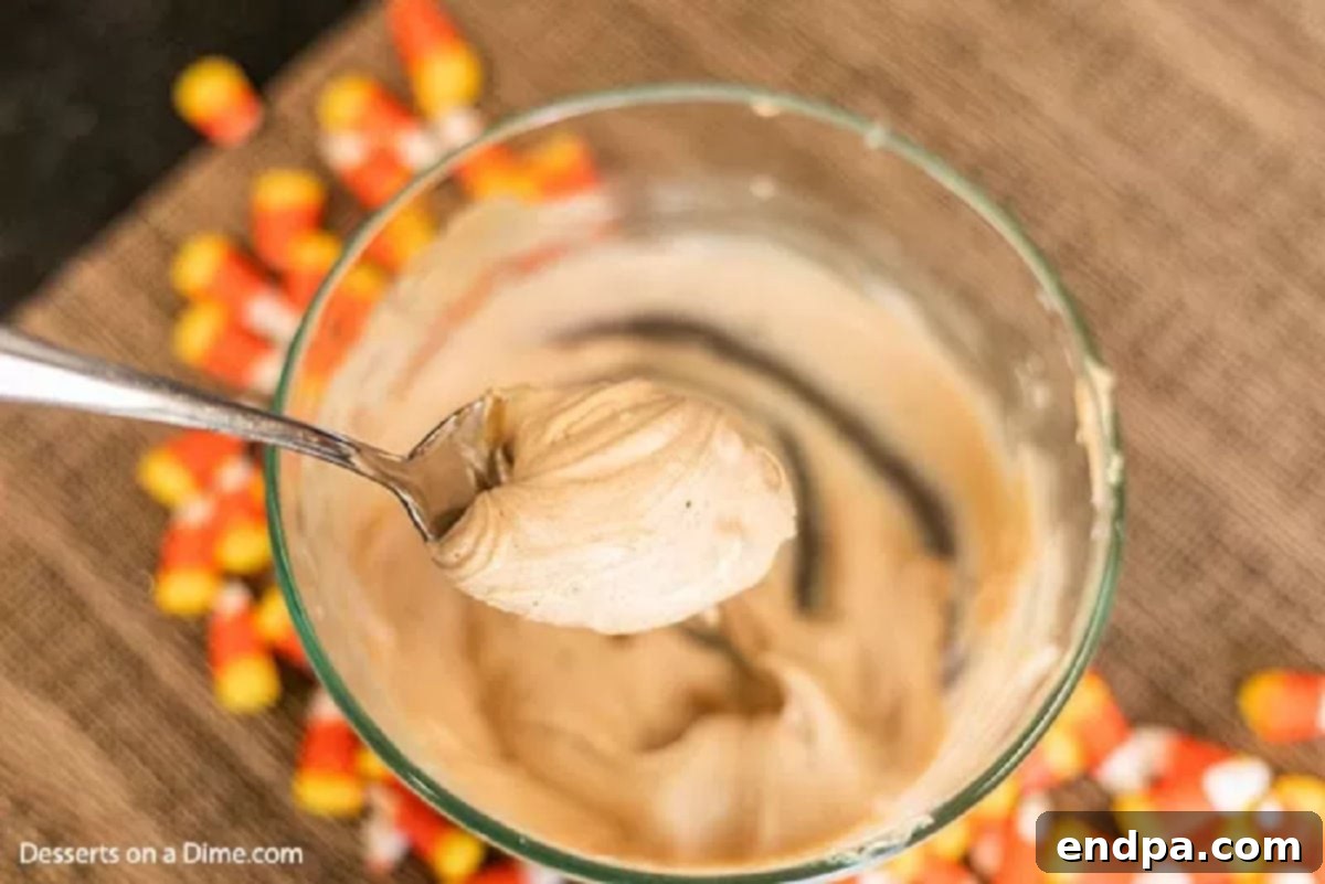 Melted peanut butter, chocolate chips, and butter combined in a microwave-safe bowl, stirred smooth and ready to coat cereal.