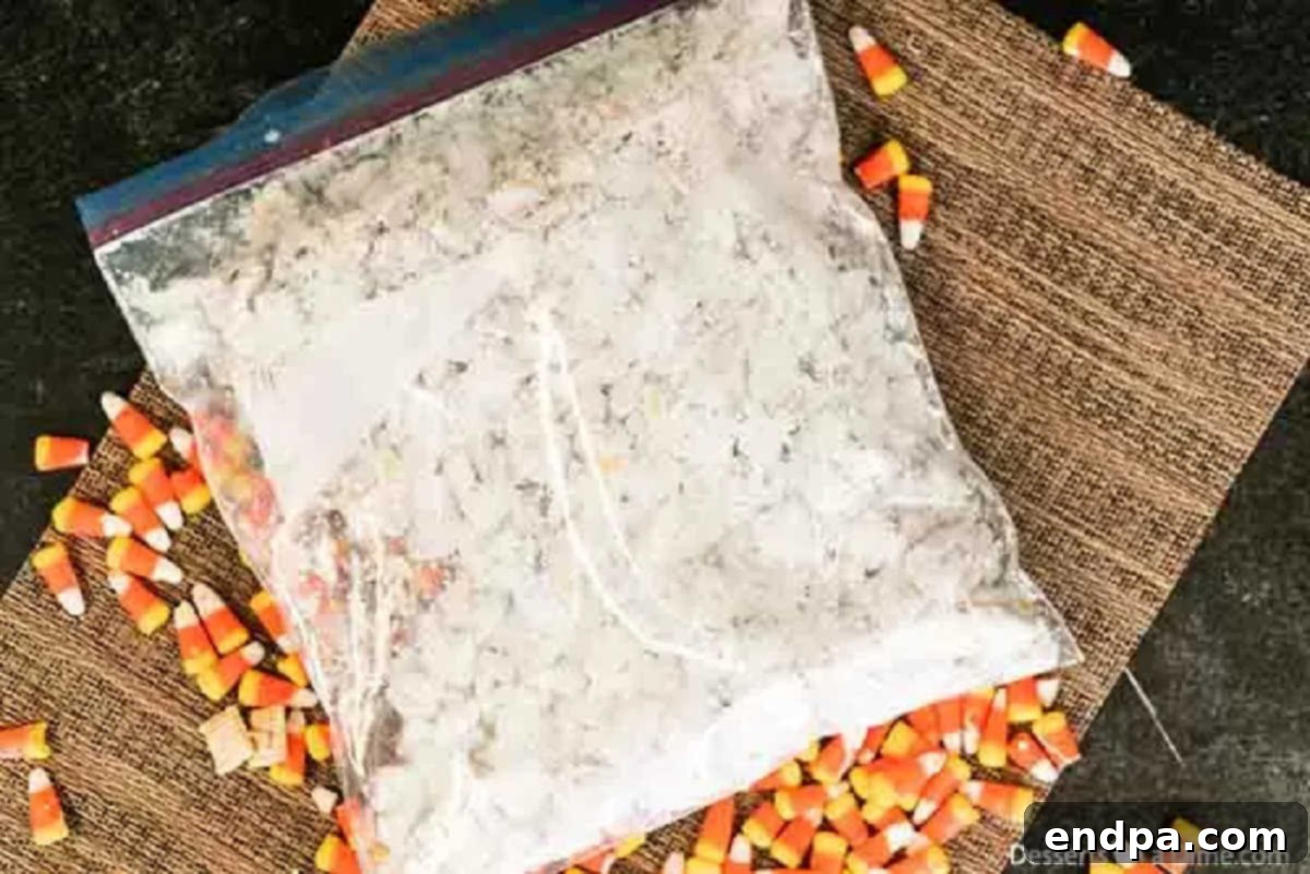 Chocolate-coated Chex cereal being shaken in a gallon-sized ziplock bag with powdered sugar to create the classic 'muddy buddies' finish.