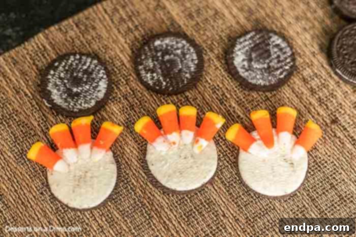 Gobble Gobble Oreo Delights 2 An Oreo cookie with its top wafer carefully removed, revealing the cream filling, where four pieces of candy corn are strategically placed to mimic turkey feathers.