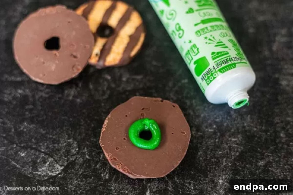 Fudge stripe cookies with green icing piped in a circle on the chocolate side.