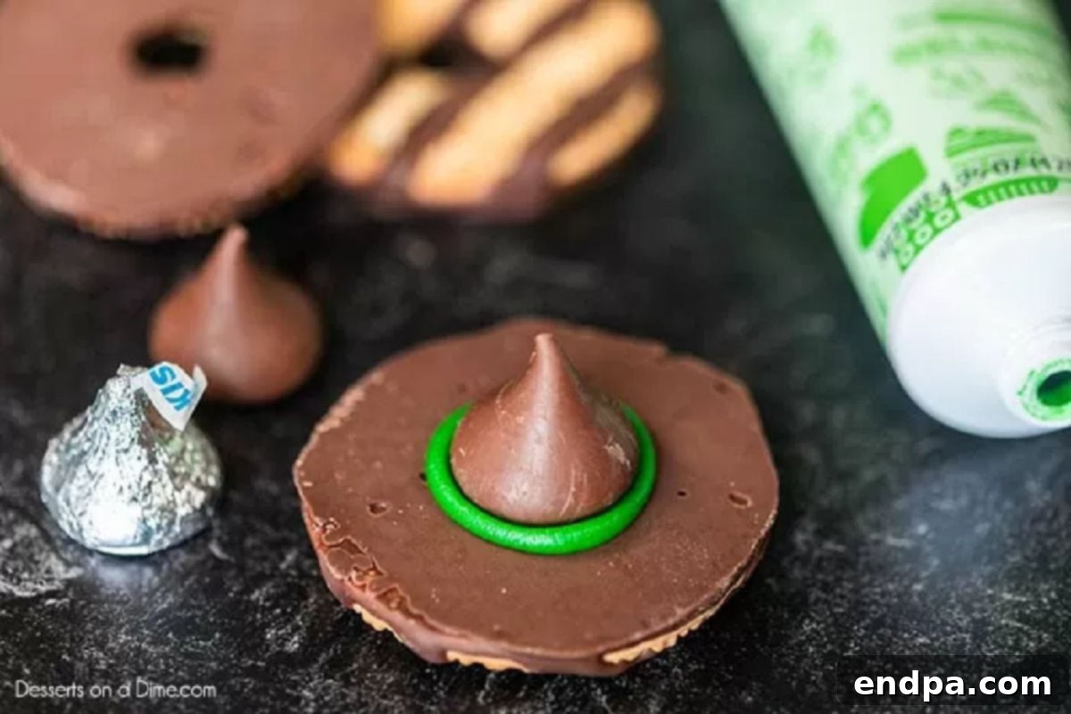 A Hershey's Kiss gently pressed onto the green icing on a fudge stripe cookie.