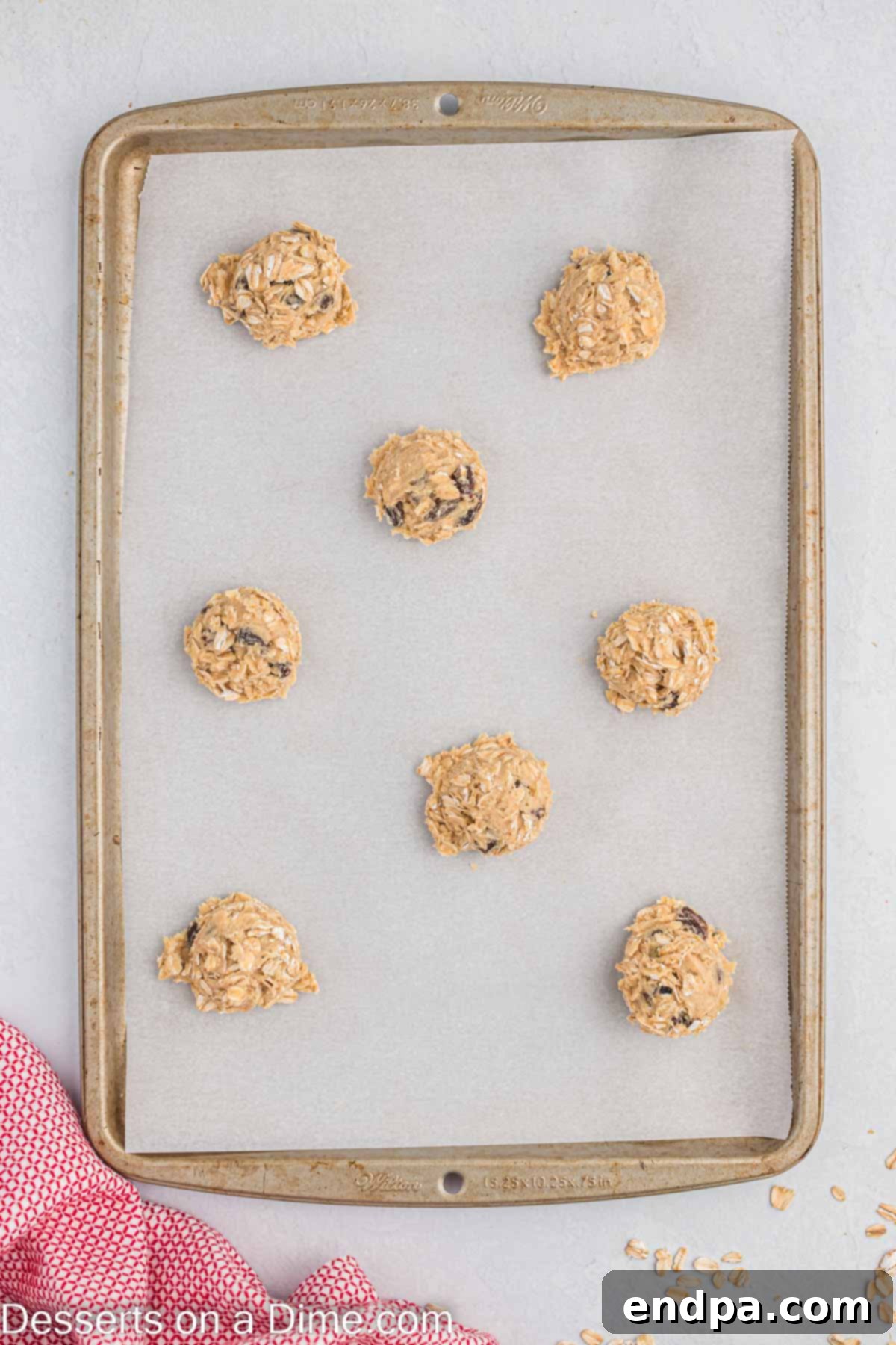 Classic Oatmeal Raisin Cookies 6 Portioned cookie dough balls arranged neatly on a baking sheet, ready for the oven.