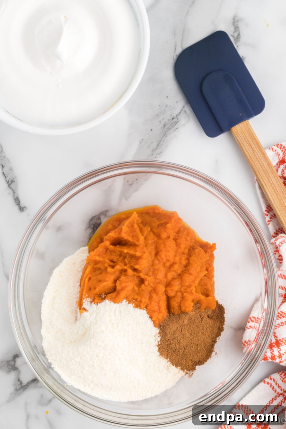 Autumn Pumpkin Fluff Dip 4 A mixing bowl with pumpkin puree and instant vanilla pudding mix, ready to be combined for the pumpkin dip.