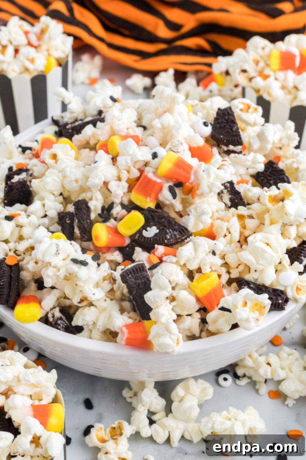Haunted Kernels 2 A festive bowl of Halloween Popcorn, garnished with colorful candy corn, crushed Oreos, and candy eyes, perfect for a spooky celebration.