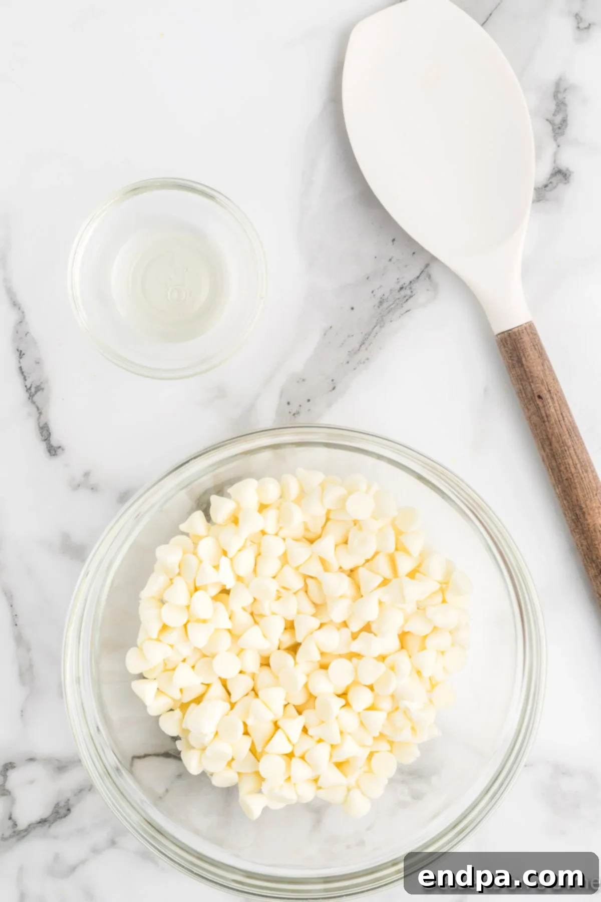 Haunted Kernels 5 White chocolate chips and vegetable oil in a microwave-safe bowl, ready to be melted.