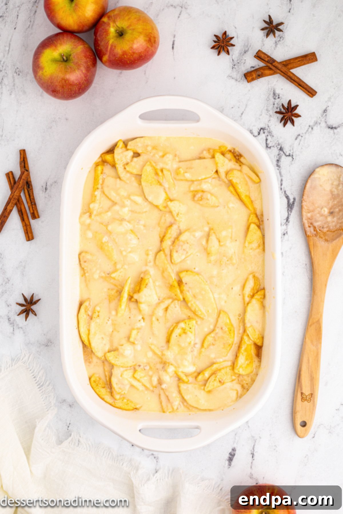 Homestyle Apple Cobbler 8 Topping mixture sprinkled over apples in baking dish.