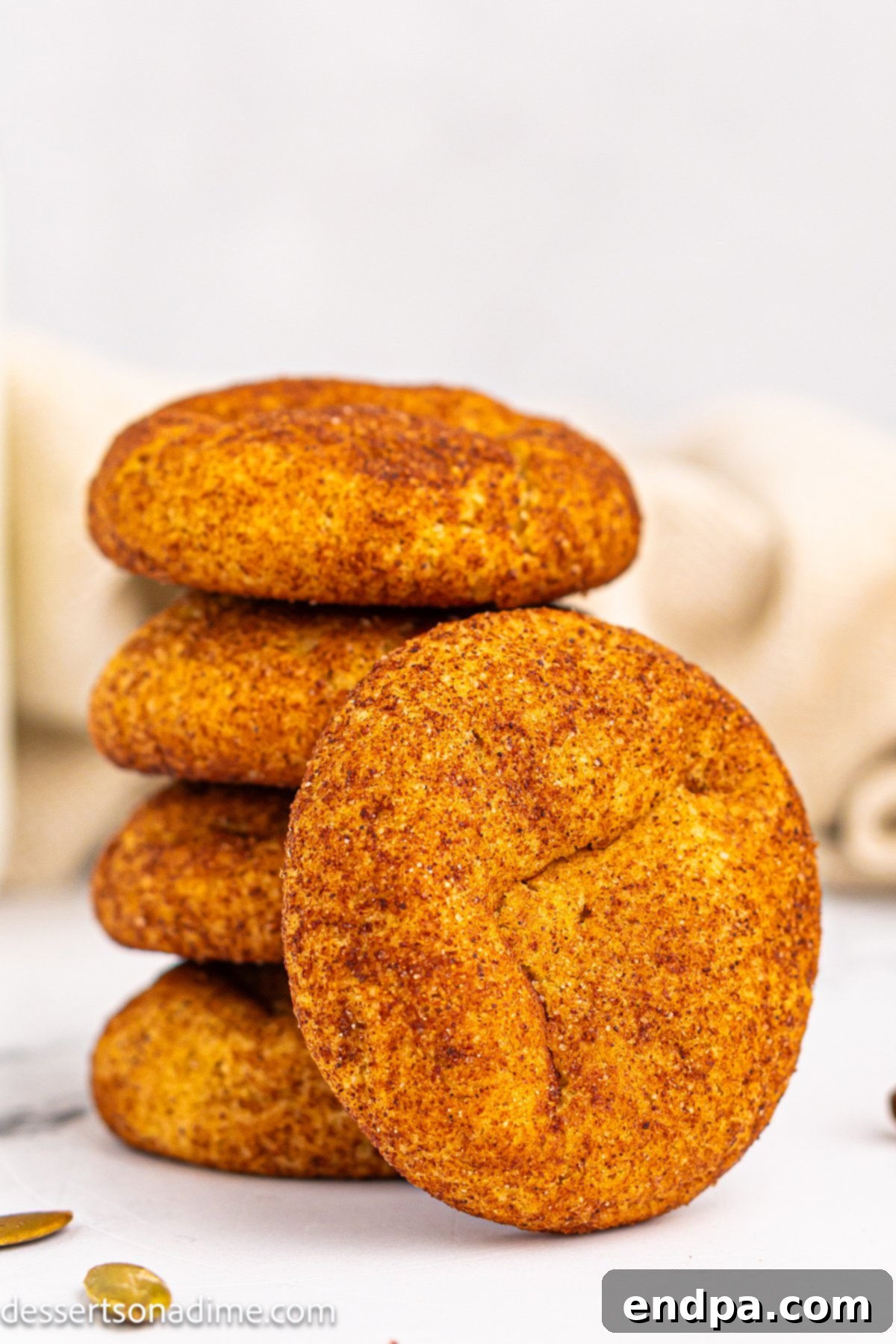 Soft and chewy Pumpkin Snickerdoodles stacked together, dusted with cinnamon sugar.