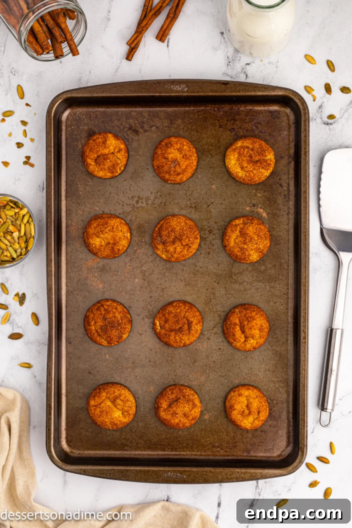 Baked Pumpkin Snickerdoodles cooling on a baking sheet.