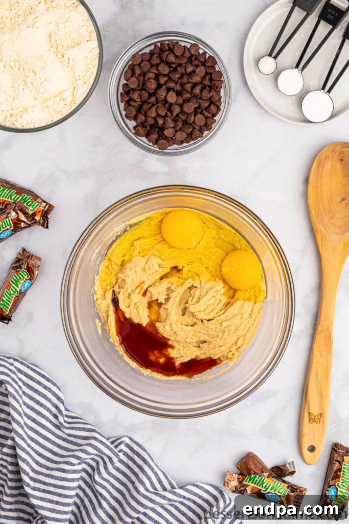 Nougat Caramel Dream Cookies 5 Room temperature eggs and vanilla extract added to the creamed butter and sugar mixture in a bowl.